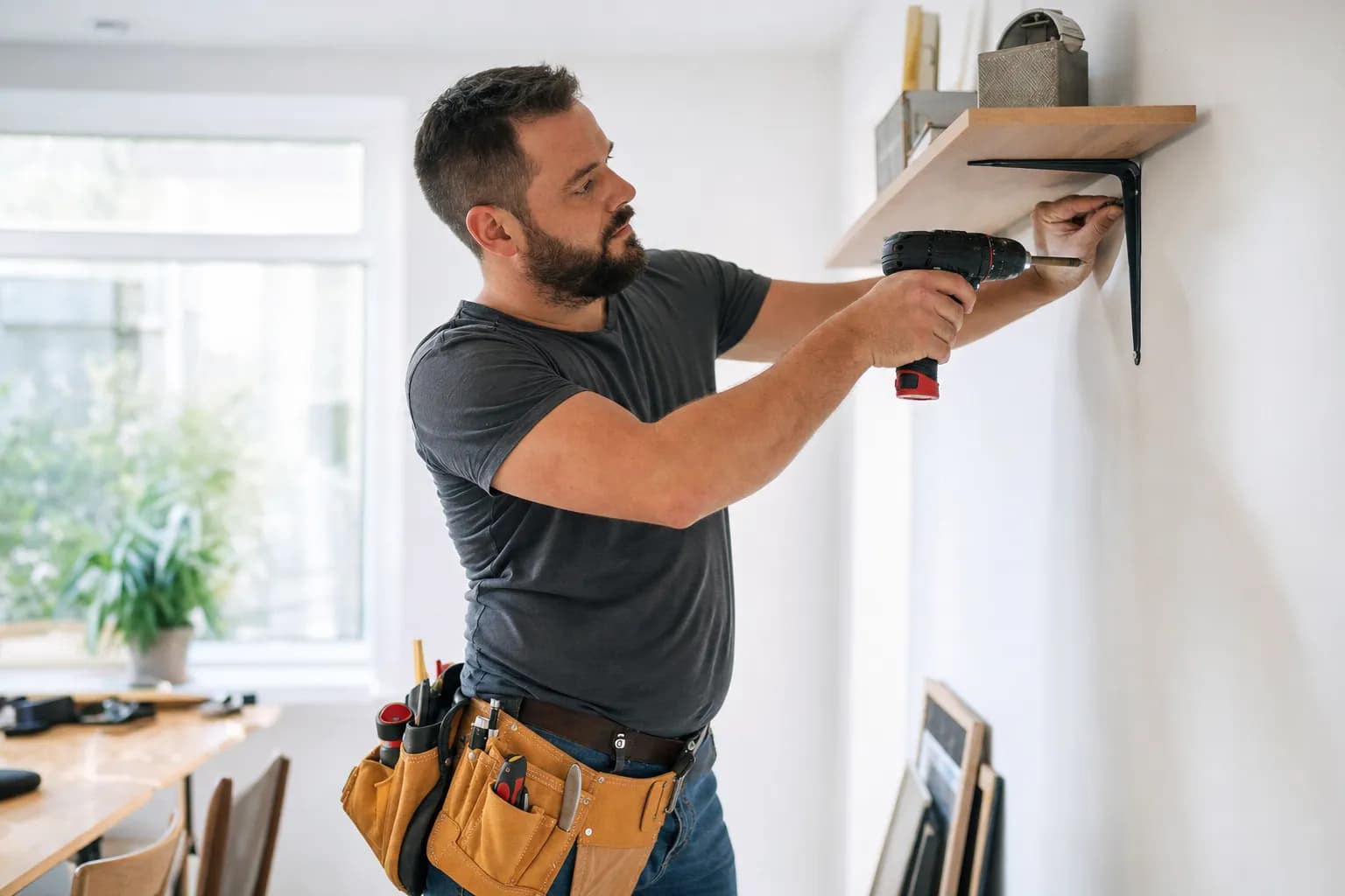 Handyman with tools doing home repair while Callbook answers incoming customer calls